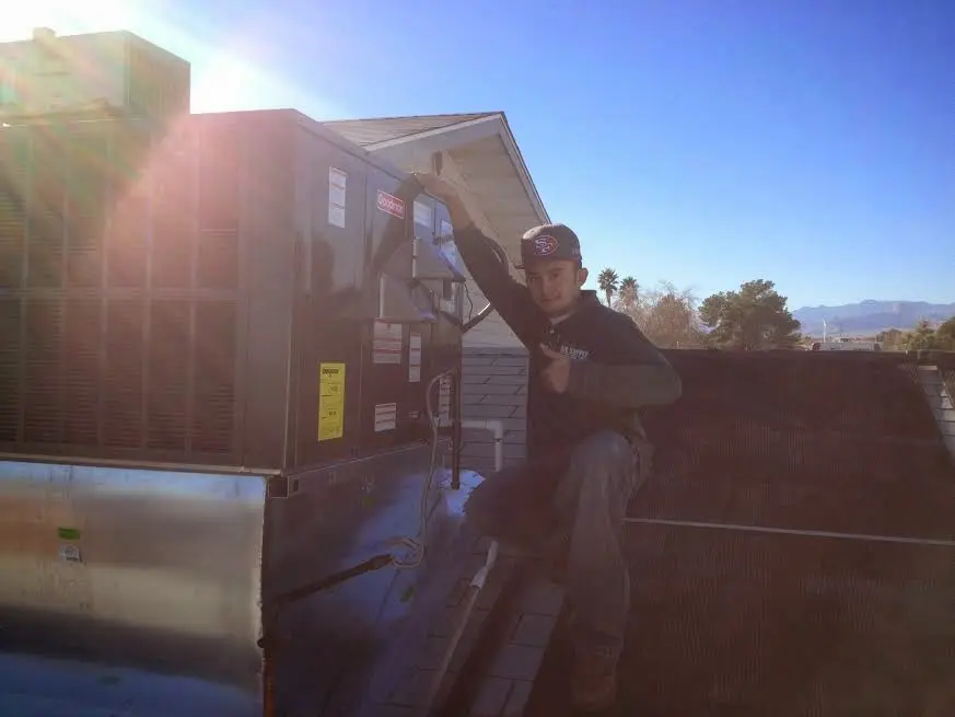 HVAC technician performing Air Duct Cleaning on a rooftop unit in Nappanee