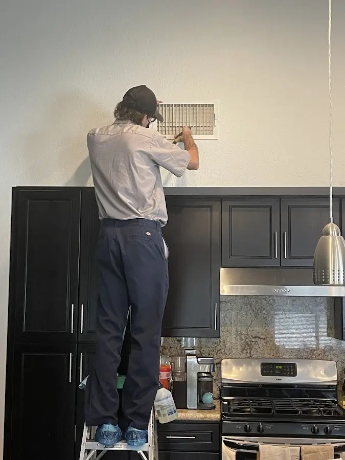 Technician inspecting an air vent during HVAC service in Nappanee